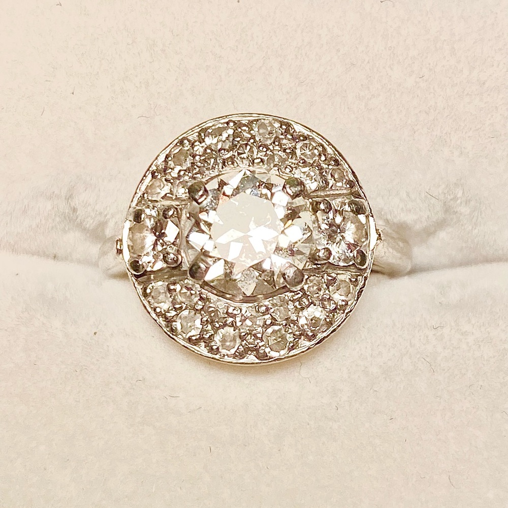 "Cartier" with a center prong Old European Cut accented with smaller diamonds.